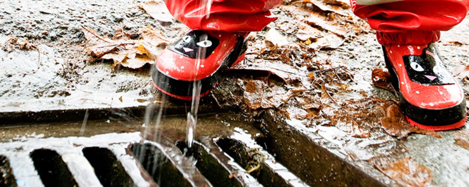 Regn faller på gallerbrunn