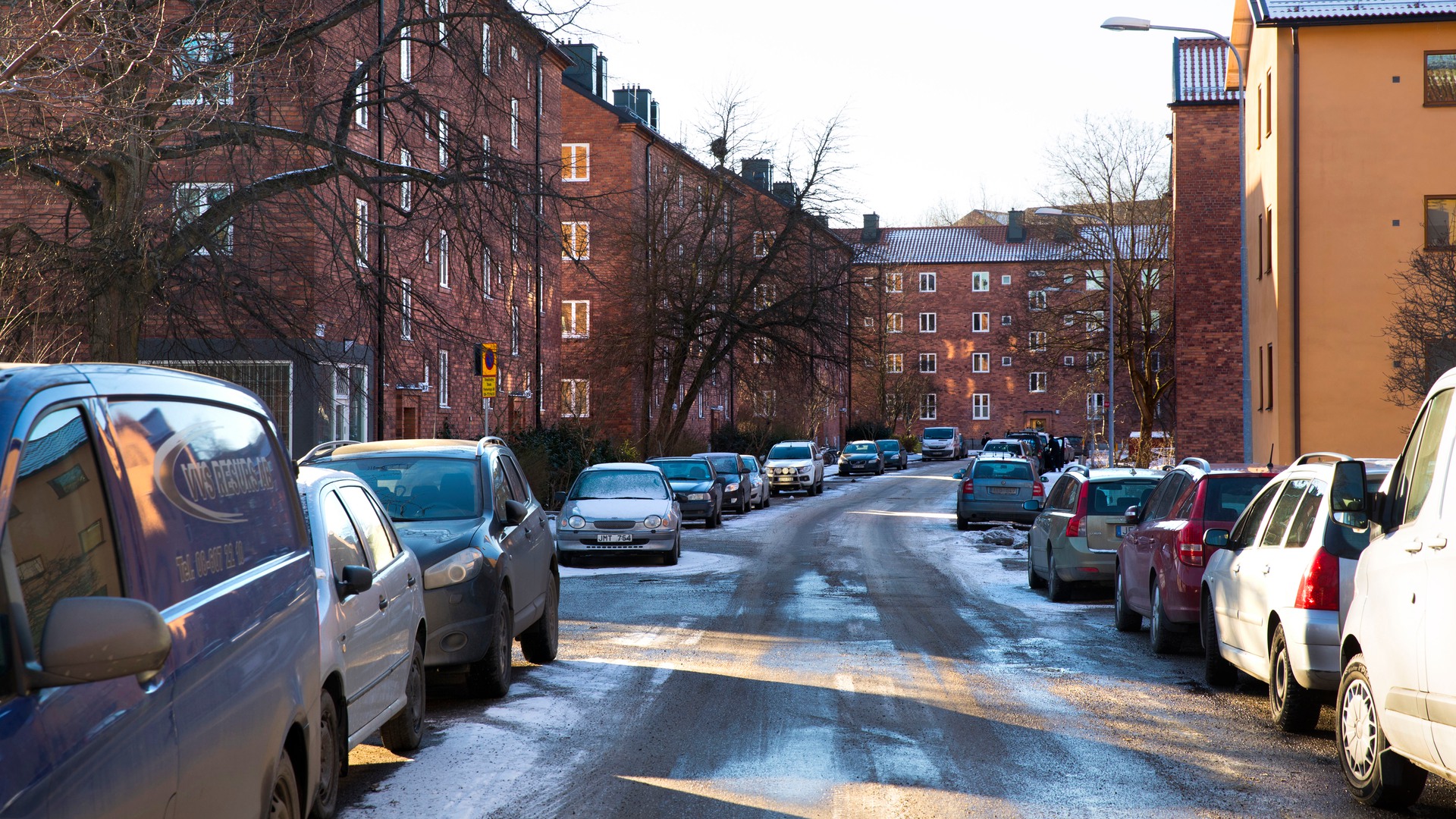 Parkerade bilar och tegelhus