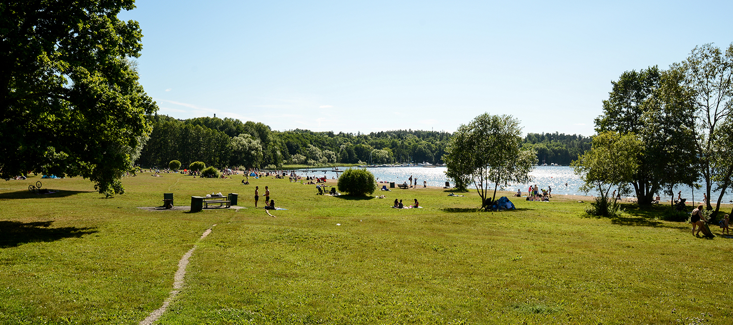 Badplats med bryggor och sandstrand